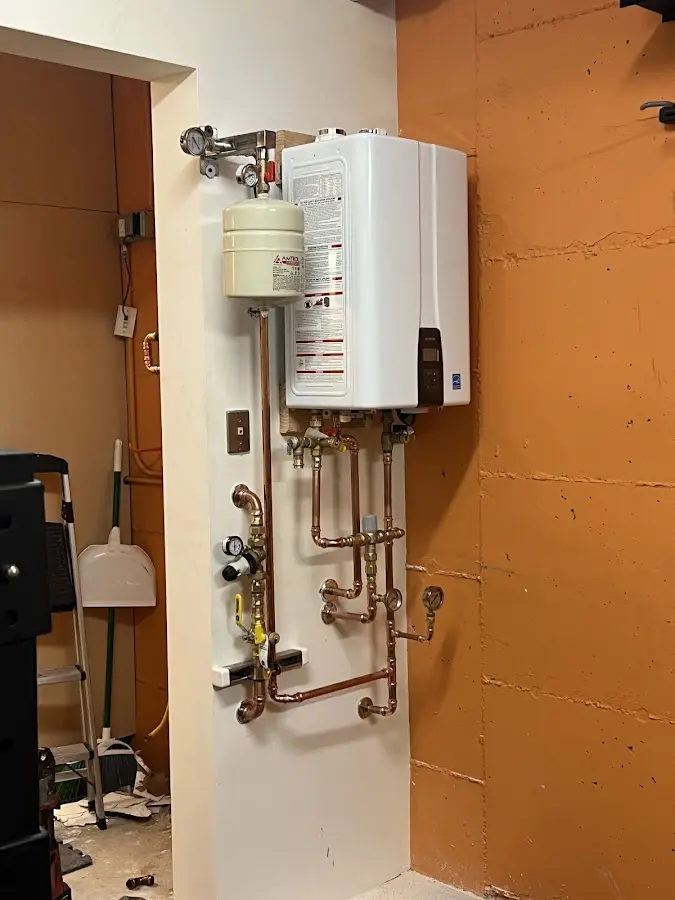 Plumbing technician inspecting water heater connections in Livingston